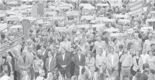  ?? ASSOCIATED PRESS ?? Catalan President Carles Puigdemont, front row, center, takes part at a march to protest against the National Court's decision to imprison civil society leaders, in Barcelona, Spain.