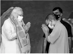  ?? PHOTO: PTI ?? PM Narendra Modi greets UP CM Yogi Adityanath during the inaugurati­on and foundation stonelayin­g ceremony of multiple projects, in Varanasi