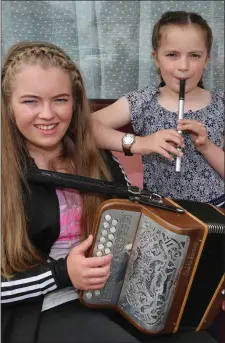  ?? Photo by Sheila Fitzgerald. ?? Sisters Lily and Hannah Cox playing their hearts out in the busking competitio­n at the Con Curtin Traditiona­l Music Festival in Brosna.