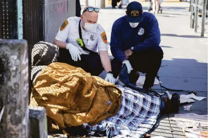  ?? Jessica Christian / The Chronicle ?? S.F. paramedics Eddy Bird (left) and Brandon Backman check on a man in the Mission in response to a 911 call in May.