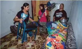  ?? [ FOTO MUHAMMAD SULAIMAN/BH ] ?? Khuriah Mohd Sahmsi mengemas rumah sambil dibantu oleh jiran selepas kejadian air pasang besar di Kampung Sri Keramat, Kapar.