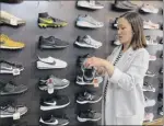  ?? Terry Chea / Associated Press ?? Jennifer Lee, whose family owns footprint shoe store in San francisco, stands by a wall of athletic shoes, many of which are made in China and will be subject to new u.s. tariffs on Chinese goods starting Sunday.