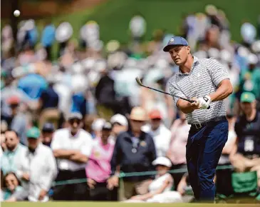  ?? Charlie Riedel/Associated Press ?? Bryson DeChambeau chips to the green on No. 7 during the first round of The Masters on Thursday at Augusta National Golf Club. DeChambeau finished with a 7-under 65, one stroke ahead of Scottie Scheffler.