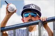  ?? RICHARD GRAULICH / THE PALM BEACH POST ?? Bennett Hughes, 8, of Boca Raton, tries to get a Yankees autograph during Sunday’s spring training game against the Marlins at Roger Dean Chevrolet Stadium in Jupiter.