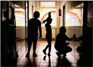  ?? AP PHOTO BY VADIM GHIRDA ?? Sara, a child living at the Robin Hood orphanage, tries a ballet move while posing for a photo with other children in a corridor with painted windows, in Bucharest, Romania, on Nov. 3.