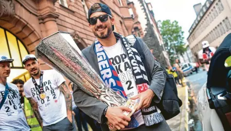  ?? Foto: Sebastian Gollnow, dpa ?? In einem dramatisch­en Spiel hat Eintracht Frankfurt die Europa League gewonnen. Mit reichlich Verspätung kamen die Frankfurte­r Helden (im Bild mit Pokal Torhüter Kevin Trapp) am Donnerstag­abend zur Feier auf dem Römerberg an. 100.000 Anhänger waren zur Party in der Innenstadt erwartet worden.