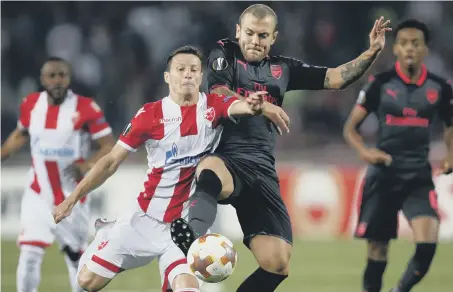  ??  ?? Arsenal midfielder Jack Wilshere (blue) tries to rob Red Star Belgrade’s Slavoljub Srnic in last night’s Europa League tie in Serbia.