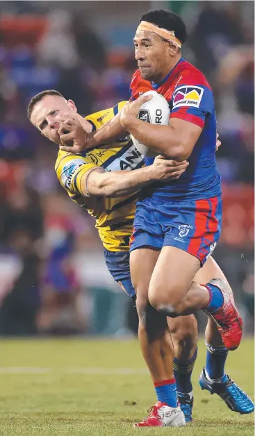  ??  ?? TUSSLE: Newcastle’s Tautau Moga fends off a tackle by Parramatta’s Nathan Brown in the clash between the two sides last night at McDonald Jones Stadium in Newcastle.