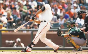  ?? Lachlan Cunningham / Getty Images 2015 ?? Madison Bumgarner, shown hitting a home run against the A’s in July, should be Exhibit A as to why the National League should not adopt the designated hitter rule.