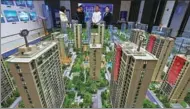  ?? WANG JILIN / FOR CHINA DAILY ?? Potential homebuyers check housing project models at a real estate agency in Qingzhou, Shandong province, in December.