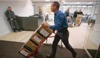  ?? Melissa Phillip / Staff photograph­er ?? Investigat­ors with the Harris County District Attorney’s Office remove boxes of files from Jared Woodfill’s law office at 3 Riverway on Monday. Woodfill is the subject of two formal complaints.