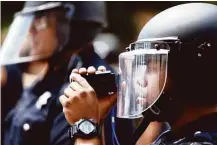  ??  ?? Houston Police Department officers monitor undocument­ed youths and their supporters, numbering about 1,000, at a rally in front of the Harris County Sheriff’s Office.