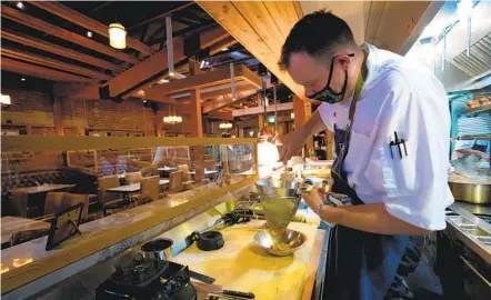  ?? NELVIN C. CEPEDA U-T ?? Tim Kropinak prepares a dish at the Cowboy Star restaurant in the East Village earlier this month. Cowboy Star is one of the eateries that filed a lawsuit seeking the reopening of indoor operations.