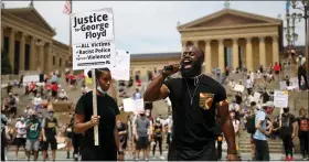  ?? TYGER WILLIAMS/THE PHILADELPH­IA INQUIRER VIA AP ?? Wallace Weaver, of Mount Airy, Philadelph­ia, speaks on the microphone to encourage protestors demonstrat­ing for justice after the death of George Floyd to register to vote at the Philadelph­ia Art Museum, Saturday June 6, in Philadelph­ia. “Let your action mirror your voice,” Weaver shouts on the mic. “It’s just super important that we don’t stop here. We have to turn the outrage into action. And that’s voting.”