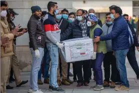  ?? (AP/Altaf Qadri) ?? Health workers move a box containing covid-19 vaccine from a vehicle to cold storage Tuesday at a hospital in New Delhi.