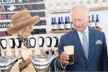  ?? PAUL CHIASSON/THE CANADIAN PRESS ?? Britain’s Prince Charles and Camilla, Duchess of Cornwall, react to a bad pour of beer the prince made on Tuesday at the Quidi Vidi Brewery in Quidi Vidi, a village in St. John’s, Newfoundla­nd. The visit came at the start of the couple’s three-day Canadian tour marking the 70th anniversar­y of Queen Elizabeth II’s ascent to the throne.