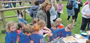  ??  ?? Joy Cameron was given plenty of help to cut her cake during a rousing send- off.