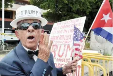  ??  ?? MIAMI: A man holds signs referencin­g US President Donald Trump’s policy on Cuba on Friday. —AFP