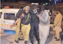  ?? ARSHAD BUTT/ASSOCIATED PRESS ?? A Pakistani volunteer and a police officer rush an injured person to a hospital in Quetta, Pakistan, Monday after two separate attacks on a police training center.