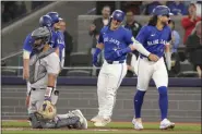  ?? CHRIS YOUNG — THE CANADIAN PRESS VIA AP ?? The Blue Jays’ Daulton Varsho, center, celebrates at the plate after hitting a grand slam off Rockies pitcher Dakota Hudson during the first inning in Toronto on Saturday,