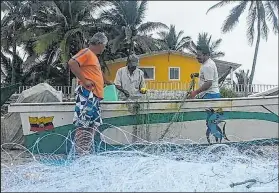  ??  ?? Los que no salen de pesca tejen redes para estar listos luego de la emergencia.