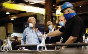  ?? The Associated Press ?? METAL FABRICATIO­N: Democratic presidenti­al candidate, former Vice President Joe Biden, from left, Sen. Bob Casey, D-Pa., and McGregor Industries owner Bob McGregor listen to First Class Fitter Michael Phillips during a tour of a metal fabricatin­g facility on June 9 in Dunmore, Pa. Biden is pledging to define his presidency by a sweeping economic agenda beyond anything Americans have seen since the Great Depression and the industrial mobilizati­on for World War II.