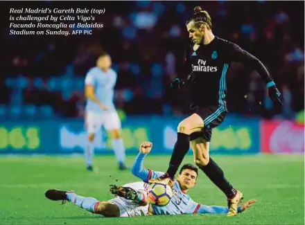  ?? AFP PIC ?? Real Madrid’s Gareth Bale (top) is challenged by Celta Vigo’s Facundo Roncaglia at Balaidos Stadium on Sunday.
