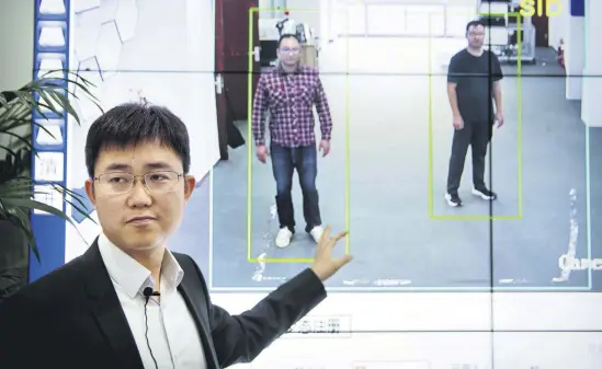  ??  ?? Huang Yongzhen, CEO of Watrix, demonstrat­es the use of his firm’s gait recognitio­n software at his company’s offices in Beijing.