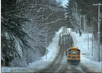  ?? Robert F. Bukaty The Associated Press ?? A school bus travels down a slush-covered road Wednesday as school resumes after a winter storm in Poland, Maine. The heavy, wet snow caused widespread power outages.