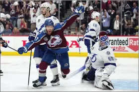  ?? JOHN LOCHER — THE ASSOCIATED PRESS ?? Colorado Avalanche left wing J.T. Compher, left, celebrates next to Tampa Bay Lightning goaltender Andrei Vasilevski­y, right, after an overtime goal by Andre Burakovsky in Game 1 of the NHL Stanley Cup Finals on Wednesday in Denver.