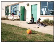  ?? (The Washington Post/Sarah L. Voisin) ?? Second grader Geofrey Arika (center right) and third grader Zechariah Walker work on their virtual studies as other students take part in recess at one of the “equity hubs.”