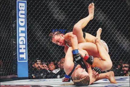  ?? ?? Maycee Barber and Katlyn Cerminara fight in a match amid Bud Light sponsorshi­p signs during UFC 299. Much of the political right — and, not incidental­ly, much of the UFC’S audience — had been pulverizin­g Bud Light for months over a promotion featuring a transgende­r inf luencer. Armed with a lucrative sponsorshi­p deal with Bud Light, Dana White appealed to friends across conservati­ve media, defending Anheuser-busch, Bud Light’s parent company.