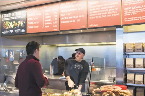  ?? Stephen Brashear / Associated Press 2015 ?? A Chipotle Mexican Grill employee prepares a burrito for a customer in Seattle. Chipotle is emphasizin­g its safety measures.