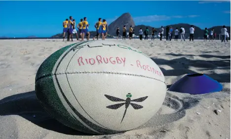  ?? CHRISTOPHE SIMON/AFP/GETTY IMAGES ?? A rugby ball awaits play at Flamengo beach in an initiative supported by Rio 2016. Rugby Sevens makes its Olympic debut next year.