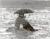  ?? DALLAS KINNEY/THE PALM BEACH POST ?? Waiting in the rain at the rock festival.