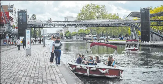  ?? The Associated Press ?? People enjoy a ride with a small boat on La Villette Canal, in Paris, France, on Saturday.
Lewis Joly