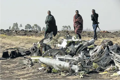  ??  ?? MORTAL METAL Ethiopian police officers among the debris of the Ethiopian Airlines Boeing 737 Max 8 aircraft that crashed soon after take-off last Sunday.