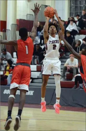  ?? TANIA BARRICKLO — DAILY FREEMAN ?? Kingston High’s Brian Moore shoots against Schenectad­y’s Lamar Fisher, left, and Christophe­r Davis during Wednesday’s game.