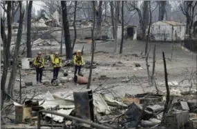  ?? MARCIO JOSE SANCHEZ — THE ASSOCIATED PRESS ?? San Bernardino County Fire department firefighte­rs assess the damage to a neighborho­od in the aftermath of a wildfire Sunday in Keswick, Calif.