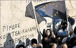  ?? ARIS MESSINIS/AFP/GETTY IMAGES ?? Protesters demonstrat­e during a pro-European demonstrat­ion in front of the Greek parliament in Athens. Leaders for the euro nations said Greek reforms were enough to break a four-month deadlock in talks.