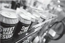  ?? KARL MERTON FERRON/BALTIMORE SUN ?? Relabeled, unused cans sold by a cider canning company move toward the end of the line at DuClaw Brewing Co. on Tuesday.