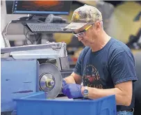  ??  ?? Steve Hill works with artificial bone parts on the buffing wheel at Zimmer Biomet in Warsaw, Ind. Quality control is crucial for medical implants, which helps keep manufactur­ing in the United States.