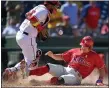  ?? NICK WASS — THE ASSOCIATED PRESS ?? The Phillies’ J.T. Realmuto, right, slides home to score on a double by Andrew McCutchen in the sixth inning ahead of Nationals catcher Keibert Ruiz Thursday. McCutchen sparked a seven-run rally for the Phillies to win 7-6, their sixth straight victory.