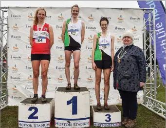  ??  ?? Senior Women’s medallists from left, Mary Mulhare of Portlaoise A.C., Co. Laois, silver, Fionnuala McCormack, gold, and Una Britton, bronze, with Athletics Ireland President Georgina Drumm during the Irish Life Health National Senior, Junior and Juvenile Even Age Cross Country Championsh­ips.