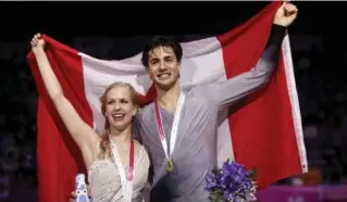  ?? ALBERT GEA/REUTERS ?? Ice dance gold medallists Kaitlyn Weaver and Andrew Poje show off the Canadian flag in Barcelona on Saturday.