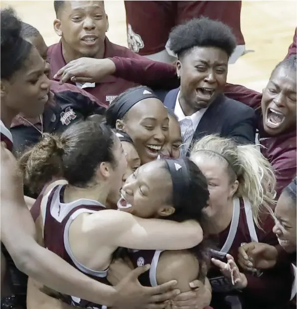  ?? (Photo by Eric Gay, AP) ?? Mississipp­i State's Morgan William, middle, is mobbed by teammates after she hit the winning shot to help the Bulldogs knock off the Connecticu­t Huskies 66-64 in overtime on March 31.