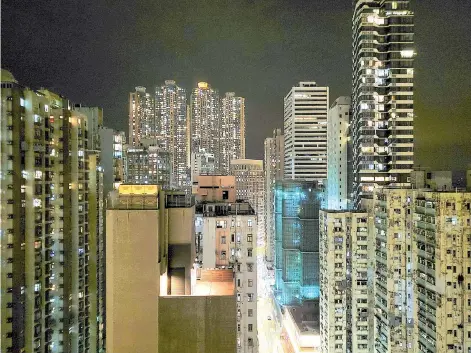  ?? — AFP photos ?? A general view of the buildings outside Tran’s window at night.