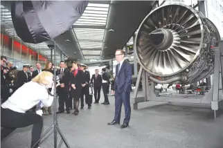  ??  ?? QANTAS CHIEF EXECUTIVE OFFICER Alan Joyce (C) is photograph­ed next to a model plane engine at their headquarte­rs after announcing the airlines annual results in Sydney on Aug. 24.