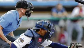  ?? AP ?? Umpires soon might have a little less on their plates. Here, Brian debrauwere wears an earpiece connected to an iphone in his baseball bag to call balls and strikes.