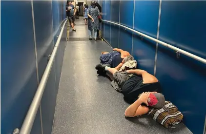  ?? ?? Travellers at Los Angeles Internatio­nal Airport sleep in a jetway for a delayed United Airlines flight to Dulles Internatio­nal Airport due to a widespread global outage early Friday, in Los Angeles. Photo : Associated Press/Stefanie Dazio